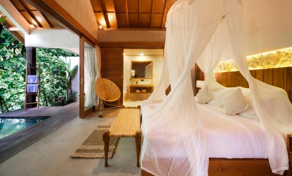 坎古卡拉帕瑜伽精品度假村 的一间卧室配有一张带蚊帐的床