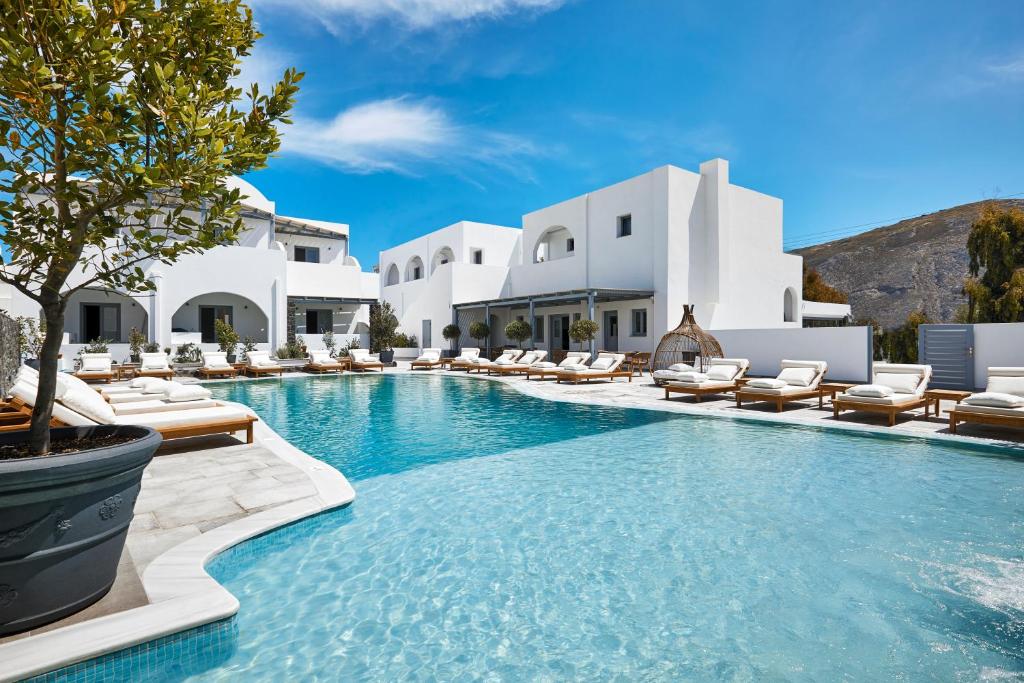 卡马利圣托里尼阿马拉套房旅馆的一个带躺椅的游泳池以及度假村
