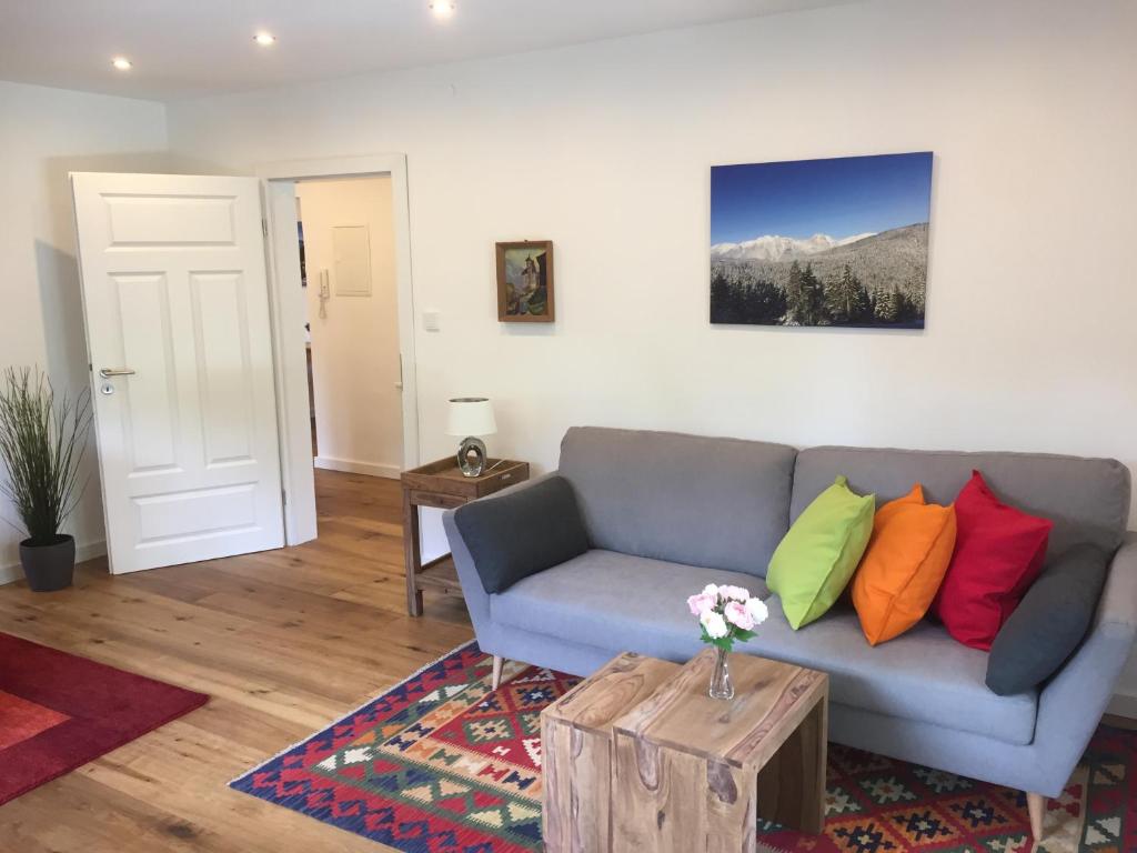 加尔米施-帕滕基兴Ferienwohnung Laurin的客厅配有带色彩缤纷枕头的灰色沙发
