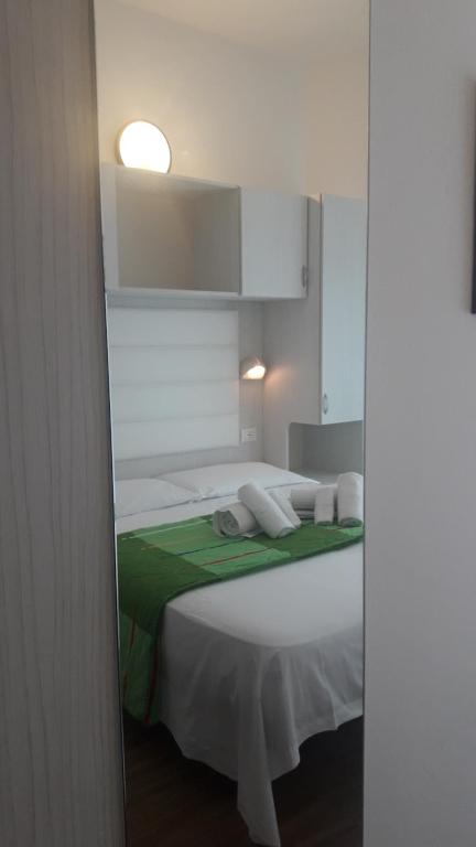 切塞纳蒂科帝国酒店的卧室配有一张带绿毯的白色床