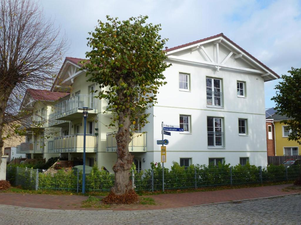 格拉尔-米里茨Ferienwohnung am Rhododendronpark, 300 m zum Strand的前面有棵树的白色建筑