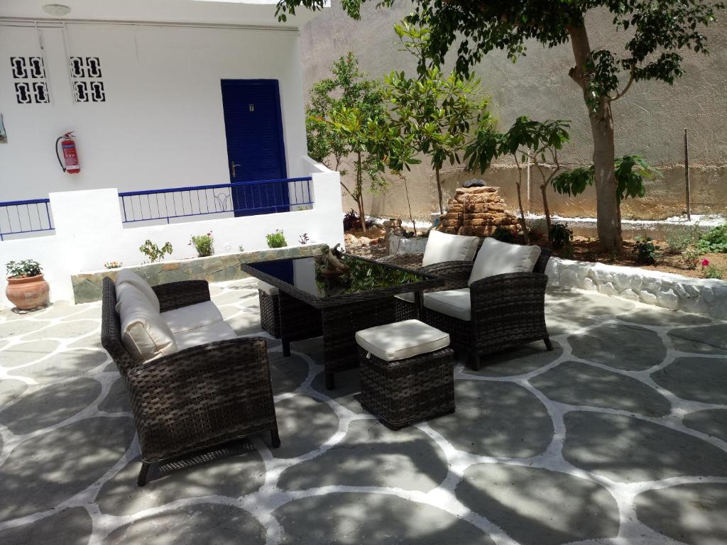 斯卡拉Hotel Poulakis的庭院配有家具和桌椅