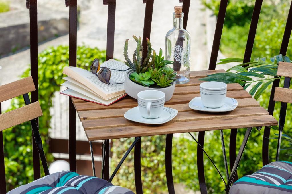 斯普利特AMI apartments的阳台上的木桌,配有咖啡杯和书籍