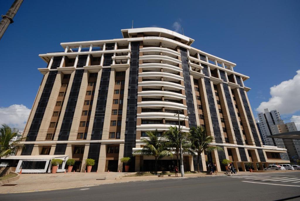 萨尔瓦多Rede Concept - Hotel Salvador的一座高大的建筑,前面有棕榈树