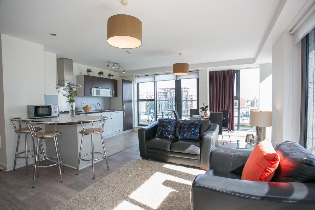 都柏林Grand Canal Square Apartments的带沙发和桌子的客厅以及厨房。