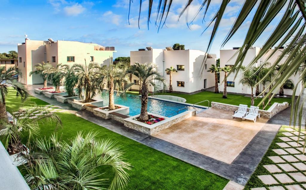 普拉加德阿罗Calma - HOLIDAY VILLAS的享有带游泳池和棕榈树的别墅的空中景致