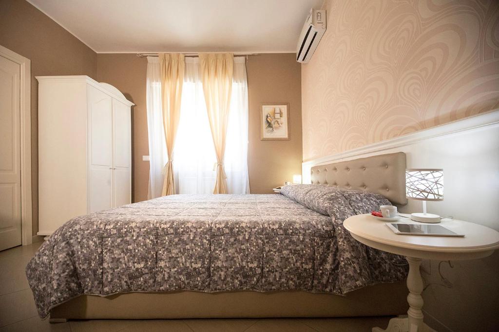 布林迪西B&B Brindesi的一间卧室配有一张床、一张桌子和一个窗户。