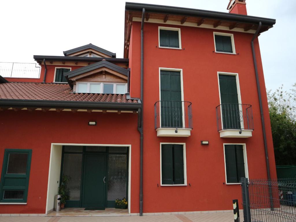 Carmignano di BrentaB&B Primula House的一座红色的建筑,设有两个阳台