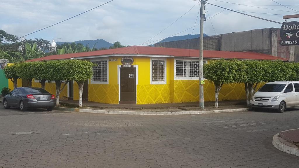 JuayúaHostal Doña Mercedes的街上有红色屋顶的黄色建筑