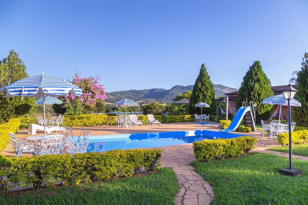 坎布基拉卢阿卢阿纳宾馆的一个带滑梯、椅子和遮阳伞的游泳池