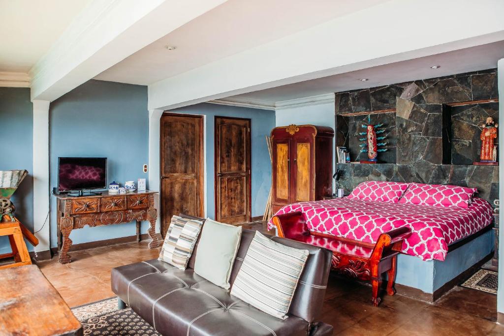 圣克鲁斯拉拉古纳Atitlan Sunset Lodge的一间卧室配有一张床和一张沙发