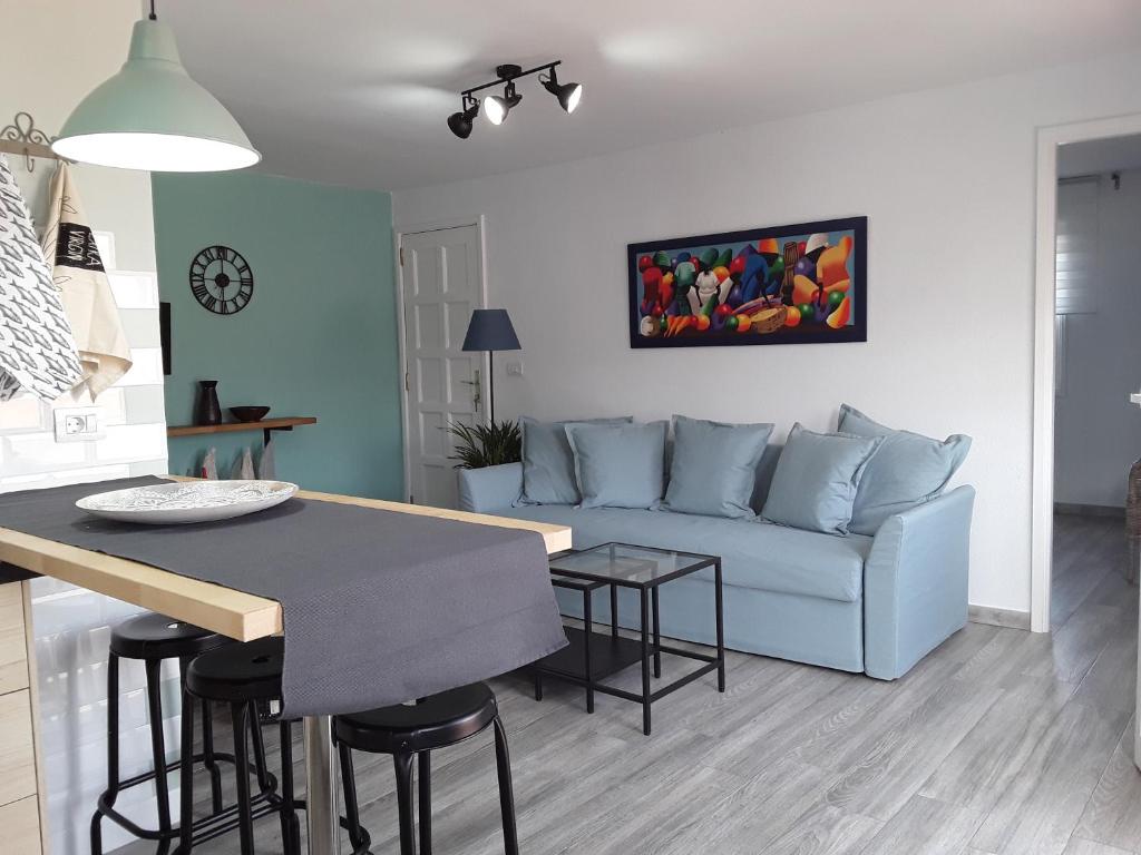 下布雷尼亚Casita La Finca I的客厅配有蓝色的沙发和桌子