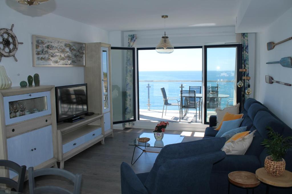 阿尔姆尼卡Dúplex playa Cabria的客厅配有蓝色沙发,享有海景