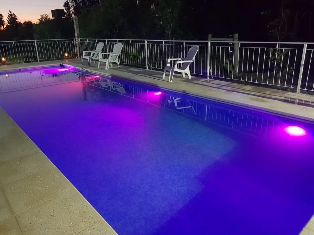 科隆Los manzanos .的游泳池在晚上有紫色的灯光