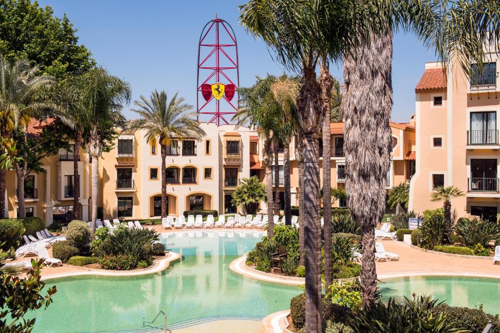 萨洛PortAventura Hotel PortAventura - Includes PortAventura Park Tickets的一个带游泳池和棕榈树的度假村
