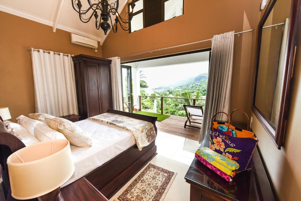 马埃岛Coconut Climb的一间卧室设有一张床,享有阳台的景色