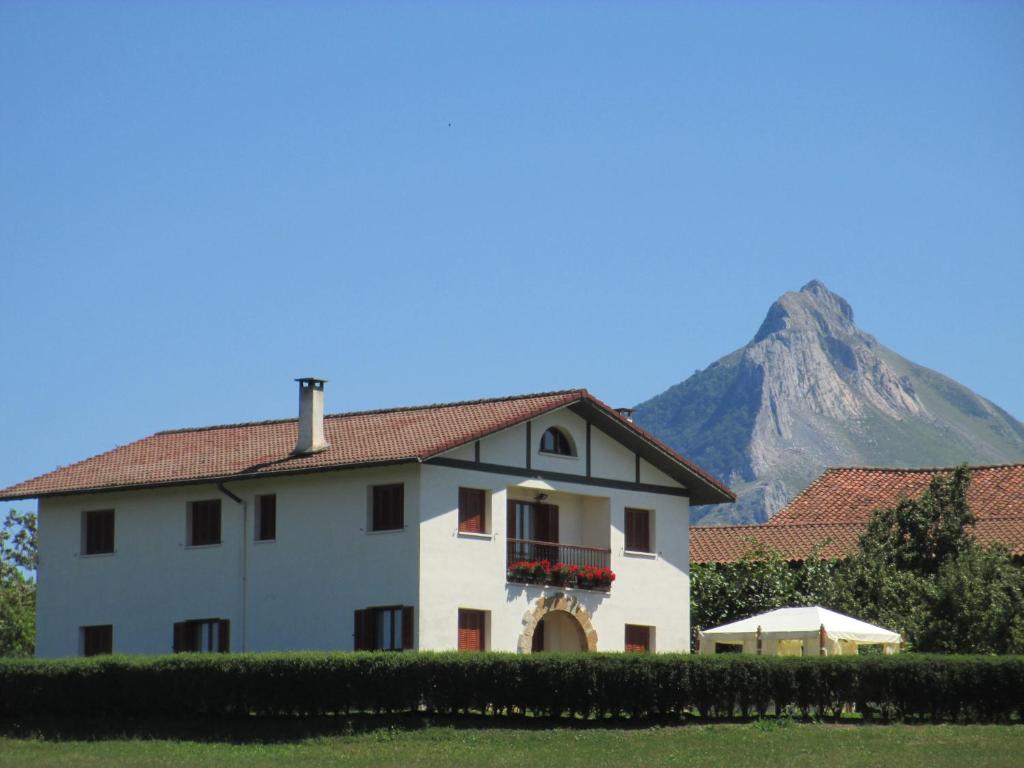 Lazcano里扎加雷特农家乐的一座白房子,后面有山