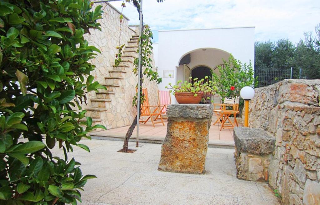 帕图Trullo Salentino的一个带桌椅的庭院和一座建筑