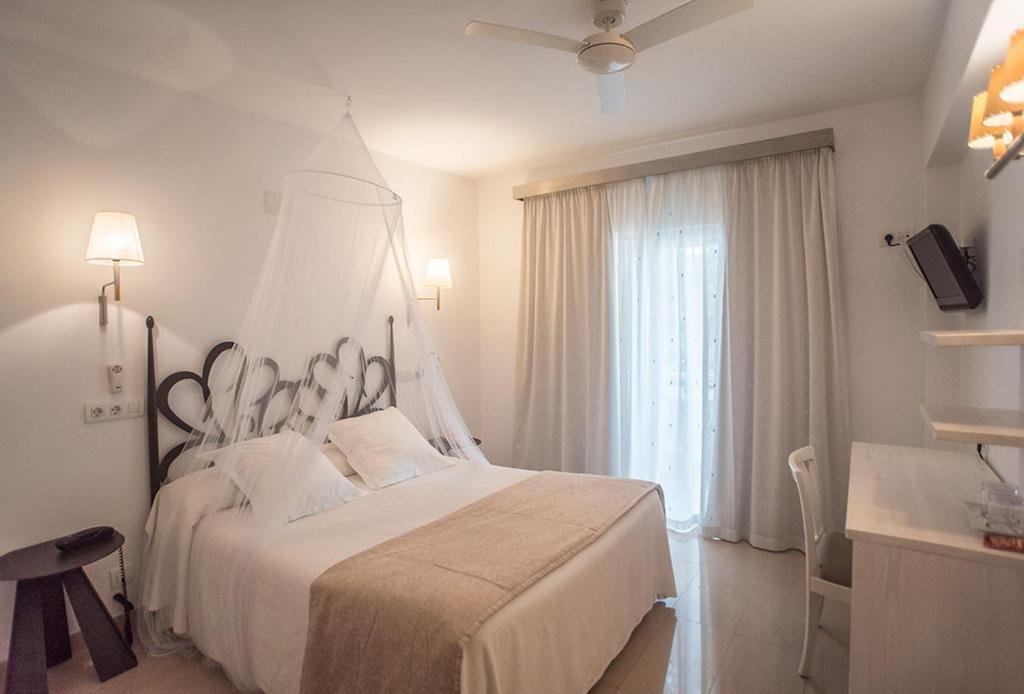 埃斯普霍斯萨沃尔特酒店的白色的卧室设有一张大床和一个窗户