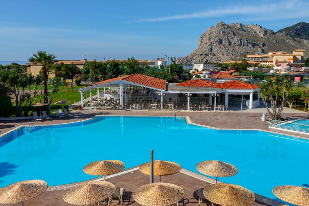 科林比亚Leonardo Kolymbia Resort Rhodes的一个带椅子和遮阳伞的大型游泳池