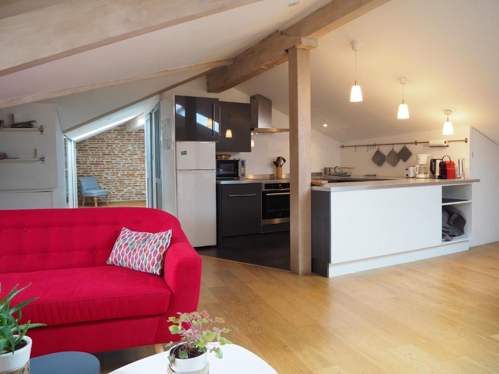 图卢兹Les Toits du Capitole - Loft de standing 60 m2 - Parking en option的一间带红色沙发的客厅和一间厨房