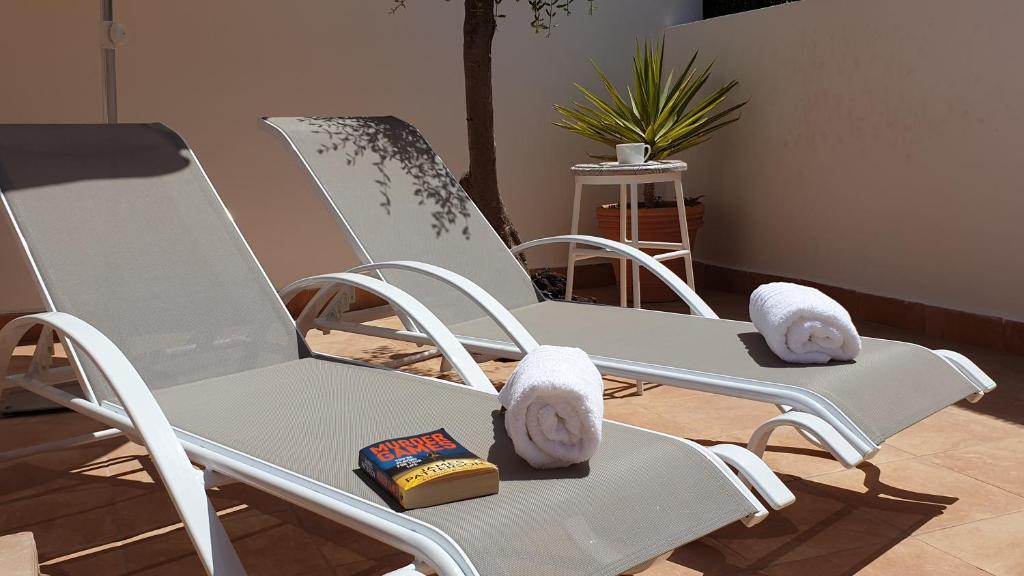 卡勒达德福斯特Sunny & New Apartamento in Caleta de Fuste的两个白色摇椅坐在房间里