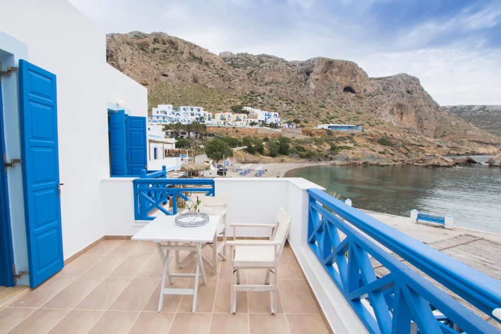 卡尔帕索斯Poseidon Luxury Apartment的阳台配有桌椅,享有水景。