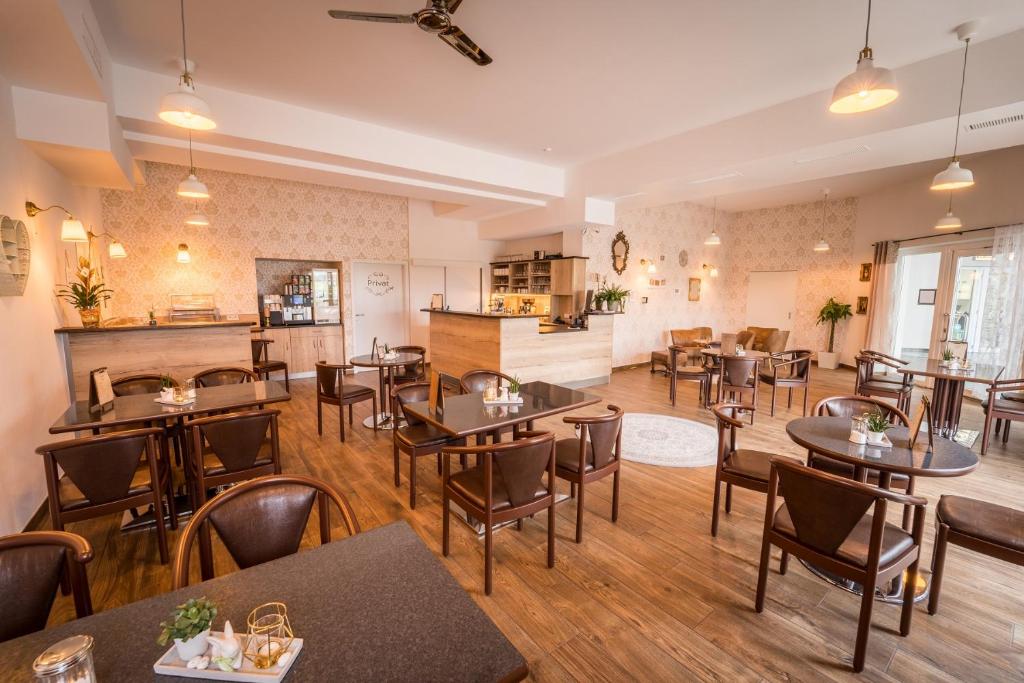 GensingenHotel Café Nahetal - Hotel garni的一间在房间内配有桌椅的餐厅