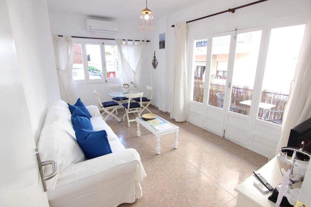 阿尔姆尼卡En el corazón de Almuñécar, piso con encanto, Wifi的客厅配有白色沙发和蓝色枕头。