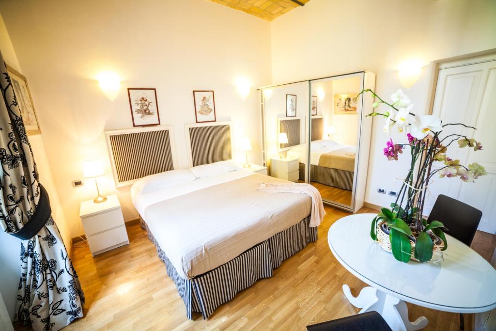 罗马帕格尼尼住宿加早餐旅馆的一间卧室配有一张床、一张桌子和一面镜子