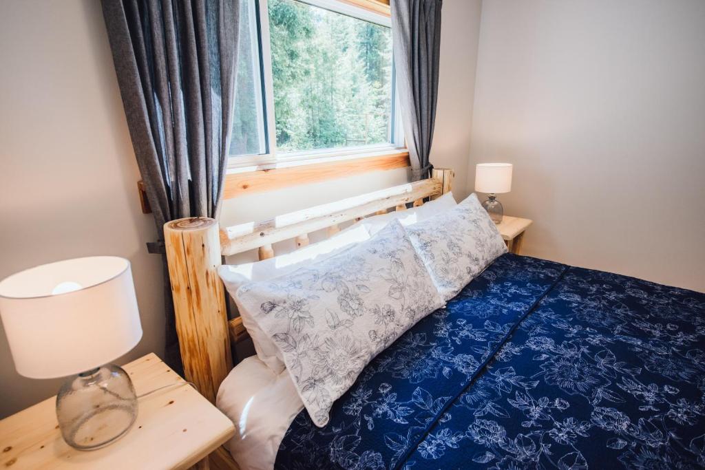 克利尔沃特Grizzly Paw B&B的一间卧室配有一张蓝色的床和窗户