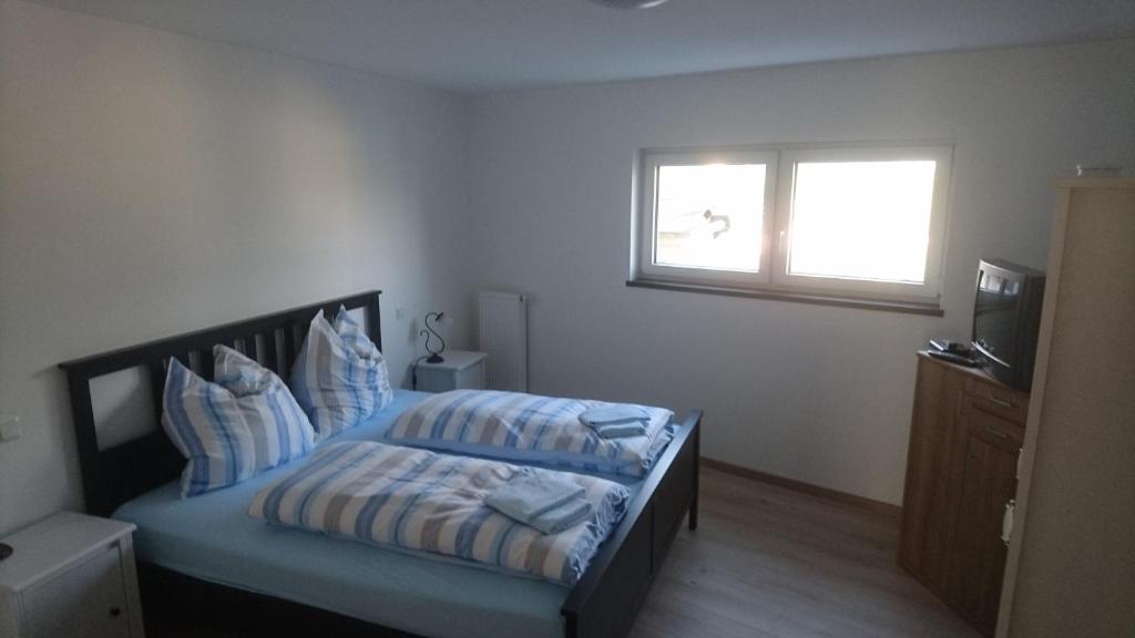 PalzemWeingut Edwin Pauly的一间卧室配有一张带蓝色床单的床和一扇窗户。