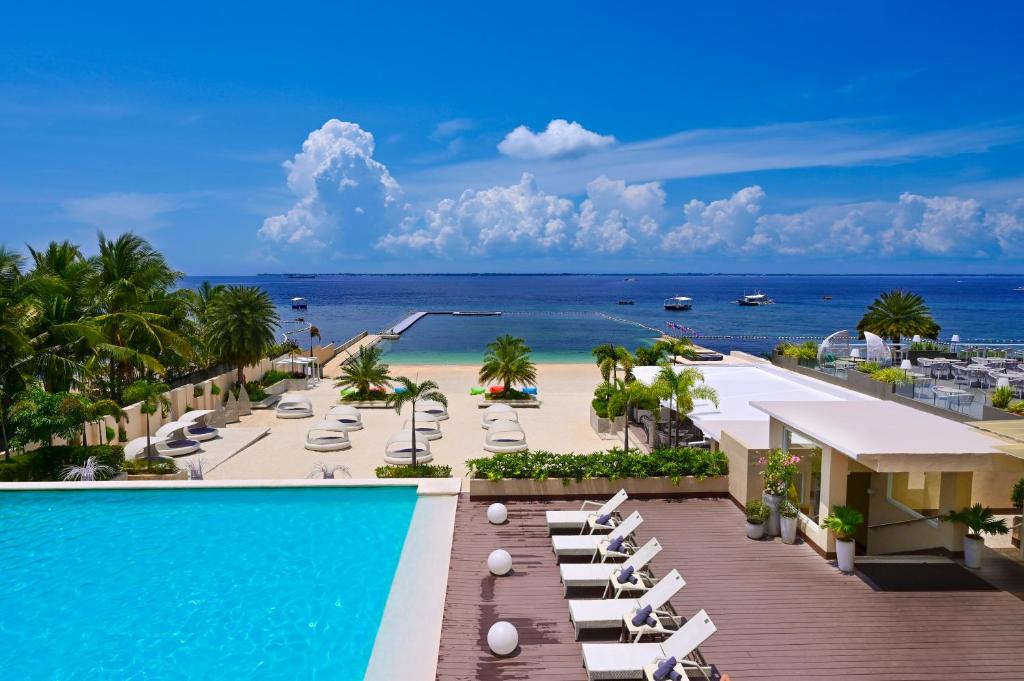 麦克坦BE Resort Mactan的享有带游泳池和海滩的度假村景色