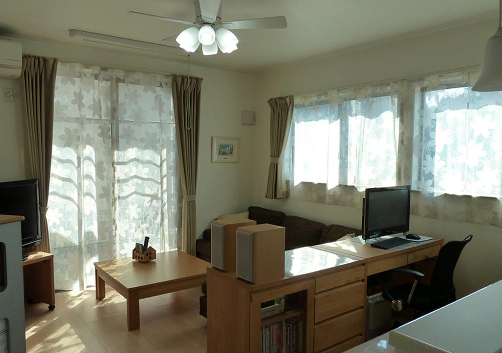 船桥市Kanaloa Funabashi的客厅配有沙发和带电脑的书桌
