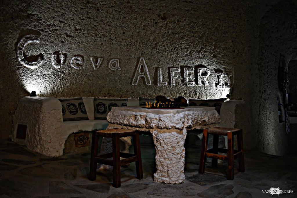 Fasnia库瓦阿尔费度假屋的洞穴内带桌子和两张凳子的房间
