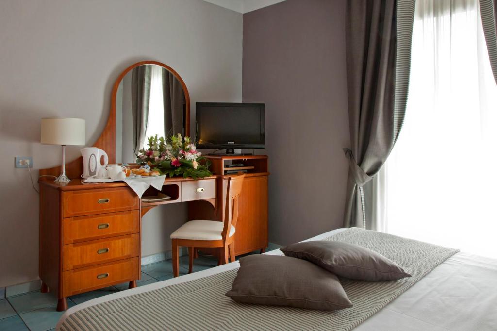 波佐利路易萨别墅酒店的一间卧室配有一张床和一张带镜子的书桌