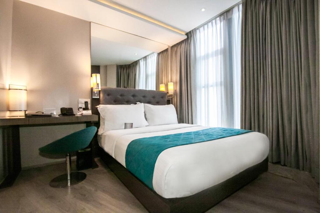 独鲁万XYZ酒店的配有一张床、一张书桌和一扇窗户的酒店客房