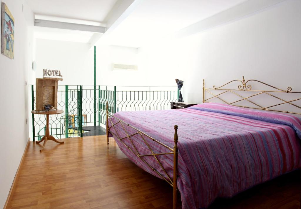 那不勒斯多米达摩酒店的一间卧室配有一张带紫色床罩的床