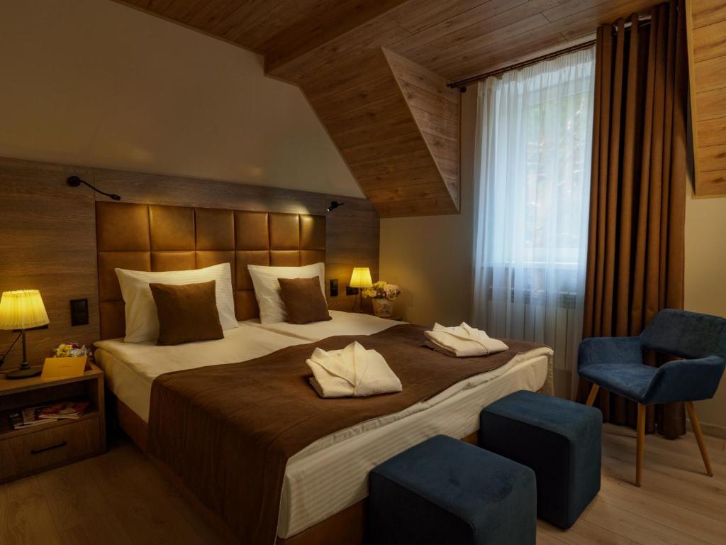 斯摩棱斯克SPA Hotel Veranda的一间卧室配有一张大床和两张蓝色椅子