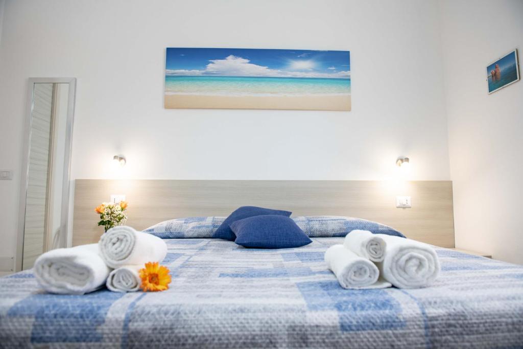 托尔托利B&B Il Viaggiatore的一张蓝色和白色的床,上面有毛巾和鲜花