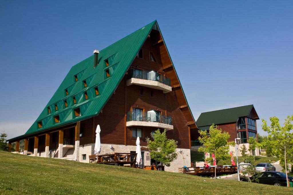 扎布利亚克北极星酒店 的山顶上带有绿色屋顶的建筑