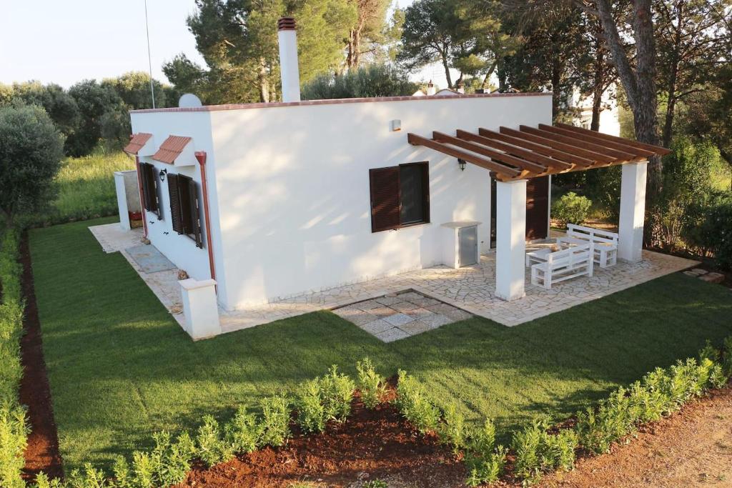 曼杜里亚Villa del Sole的白色的小房子,设有木屋顶
