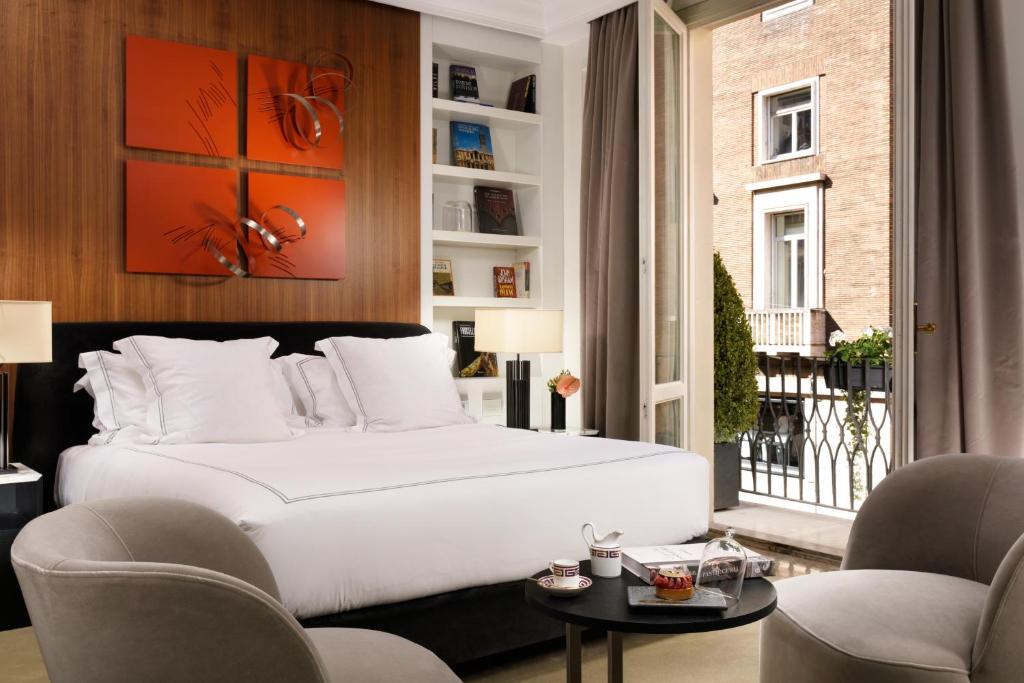 罗马The First Dolce - Preferred Hotels & Resorts的卧室配有一张白色大床和两把椅子