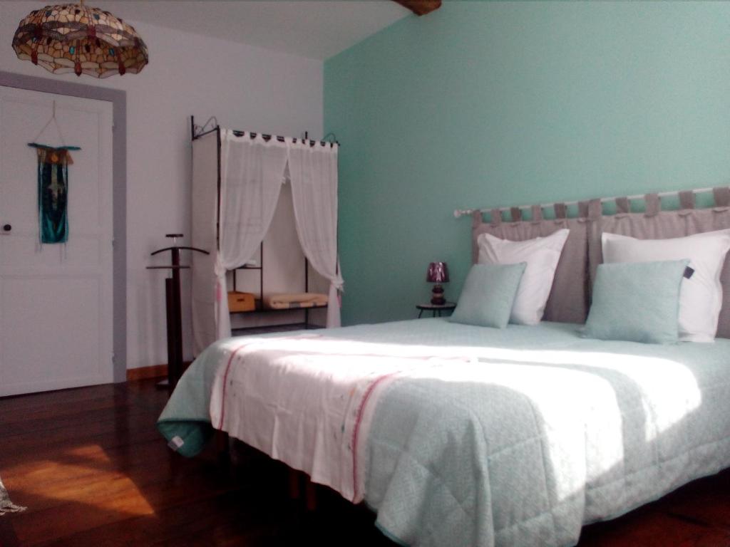 萨利耶德贝阿尔恩AUX ROSIERS的卧室配有白色大床和蓝色的墙壁