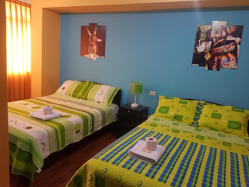 万卡约Hostal Los Pinos的一间卧室设有两张床和蓝色的墙壁