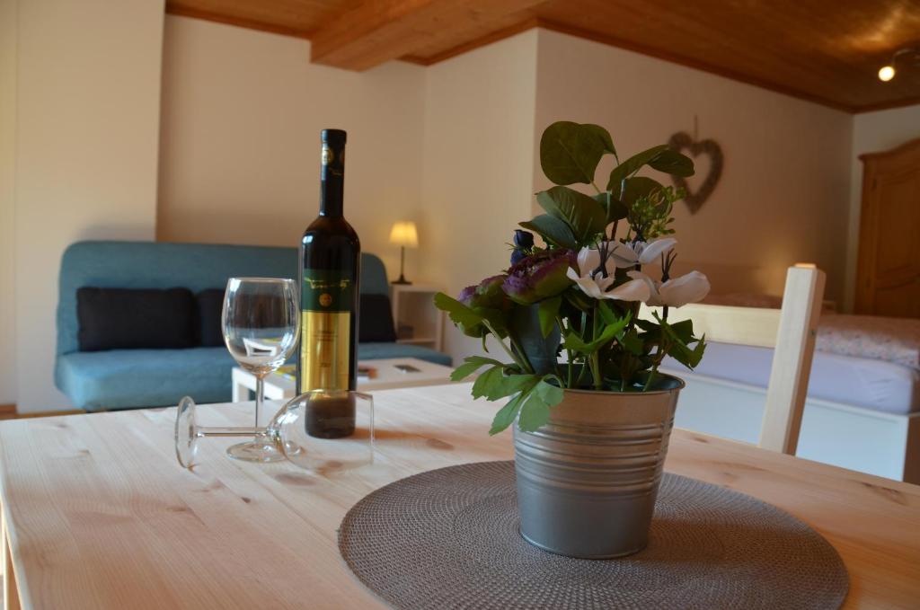 基茨比厄尔City-apart Kitzbühel Stadt的一瓶葡萄酒和一瓶花在桌子上