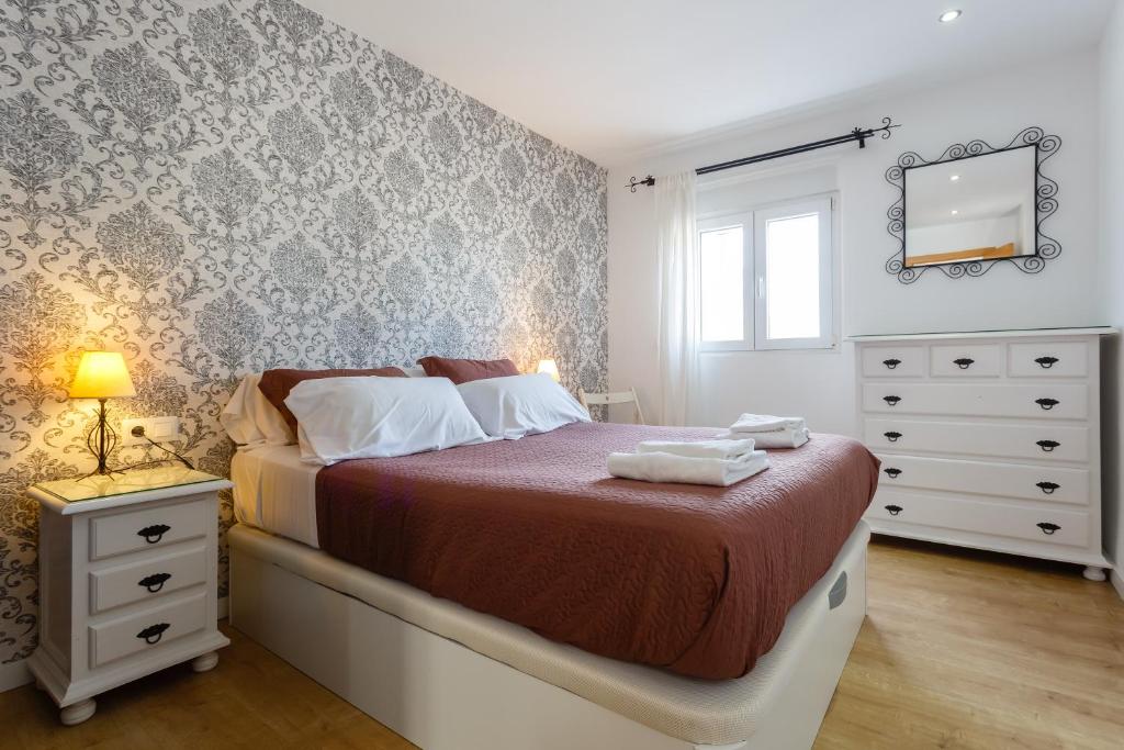 加的斯BARQUILLAS de la Caleta Home by Cadiz4Rentals的一间卧室配有一张带梳妆台和镜子的床