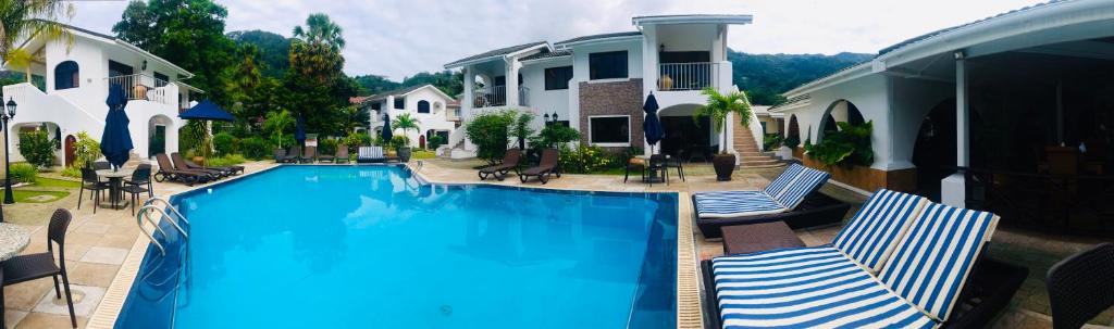 博瓦隆森普拉帕蒂斯度假酒店的一个带两把椅子的游泳池以及一座房子