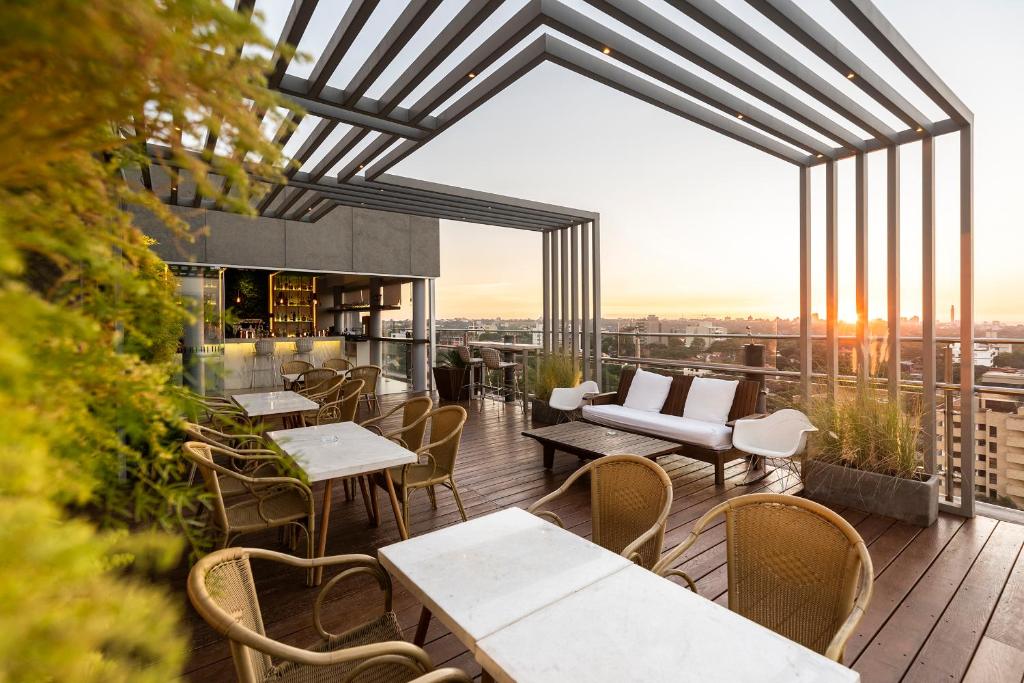 亚松森Hub Hotel Asuncion的阳台餐厅,配有桌椅