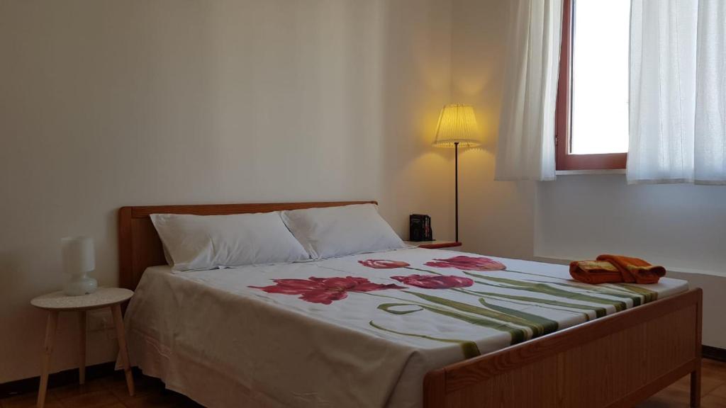 罗迪-加尔加尼科Oasi Agrumeto的一间卧室配有一张带鲜花的大床